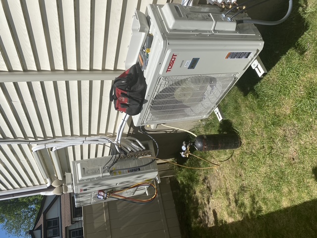Two outdoor HVAC condenser units during installation